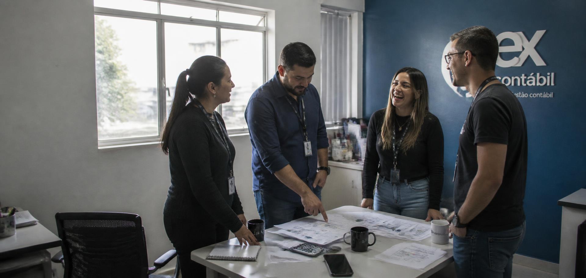 Equipe de um escritório contábil em reunião rápida analisando relatórios impressos